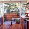 庭との間がサイドまでガラス張りになった大開口のガラスドアでつながる明るく開放的なキッチン