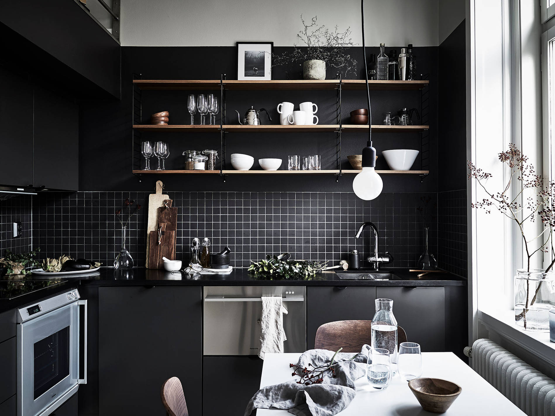 リビング・ダイニング・キッチンの脇にロフトのベッドルームのある1LDKの部屋の黒基調のシックなキッチン