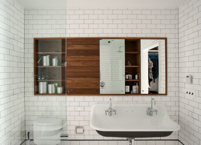白いタイルのバスルームと木製の洗面収納