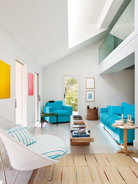 シンプルな内装にカラフルな色使いの家具を配した吹き抜けのあるリビング