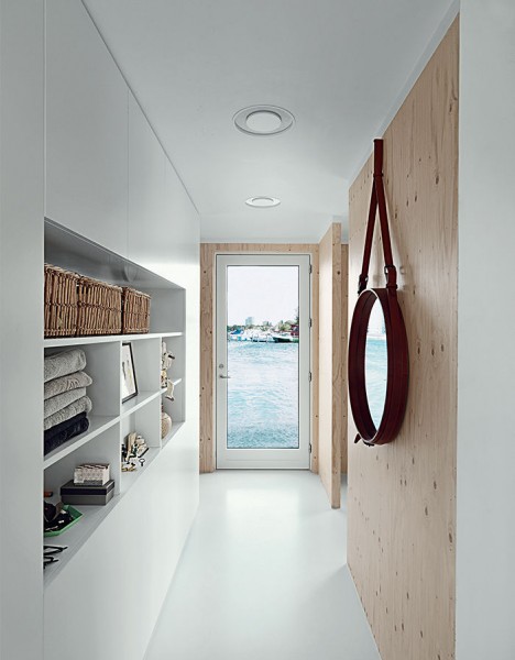 コペンハーゲン湾に浮かぶ細長いフローティング住宅のリビング・ダイニング・キッチンとベッドルームの間の廊下　構造用合板