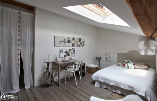 天窓のある低い天井のロフトのベッドルーム