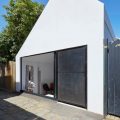 入ってすぐにリビング・ダイニング、その向こうに中庭のある60cmほど掘り下げた家の外観2